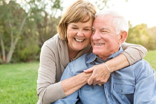 Senior couple smiling outside