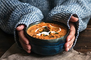 Woman holding a bowl of soup